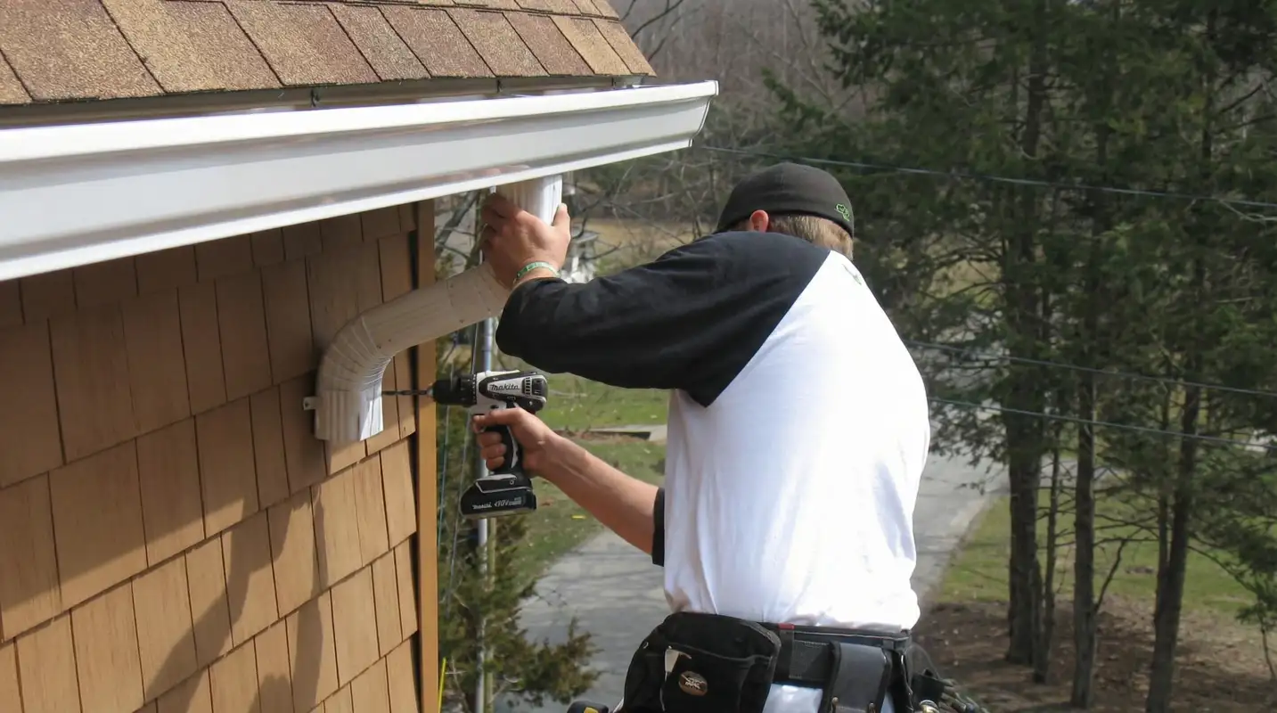 Professional contractor installing tan vinyl siding panels on a residential home exterior in Allentown, PA